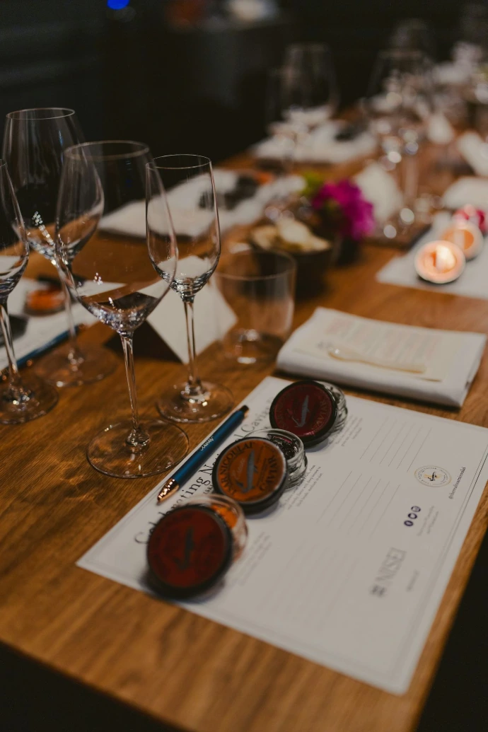 Wine glasses and tasting materials are on a table.